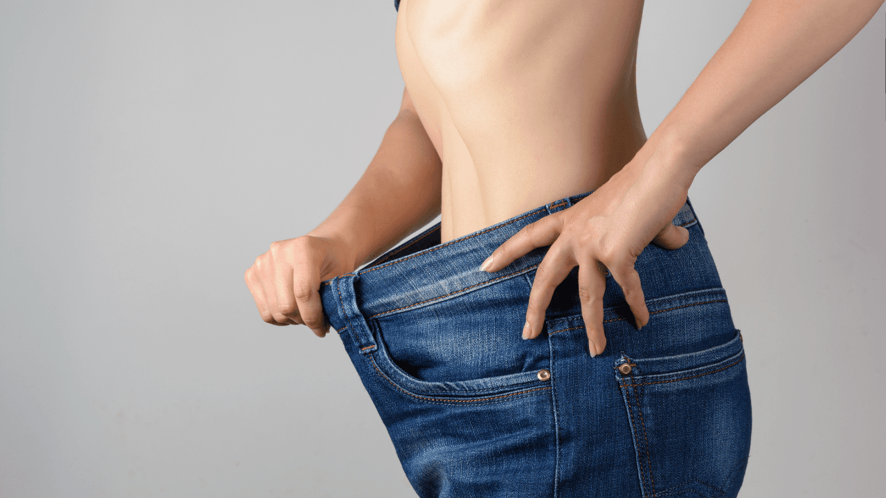 Torso of a young slim woman in big jeans. Results after training and diet. Image Credit: Adobe Stock Images/penyushkin