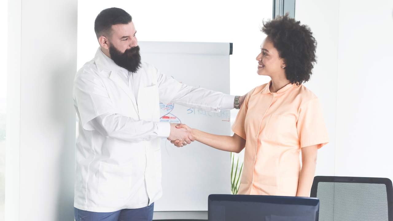 Doctor congratulating to his medical assistant. Image Credit: Adobe Stock Images/focusandblur