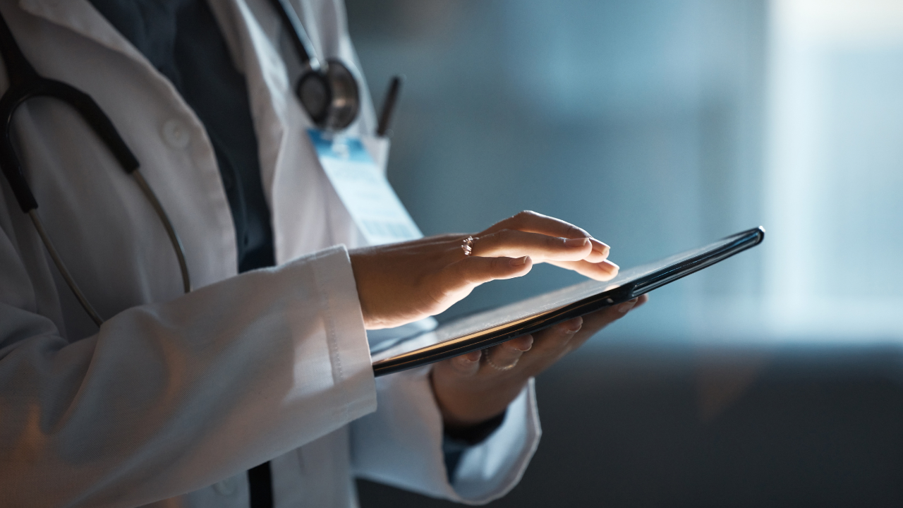 Telehealth, digital tablet and doctor hands for hospital innovation, software management and results update in dark workplace. Healthcare, cardiology and telecom medical professional with technology. Image Credit: Adobe Stock Images/Rene L/peopleimages.com